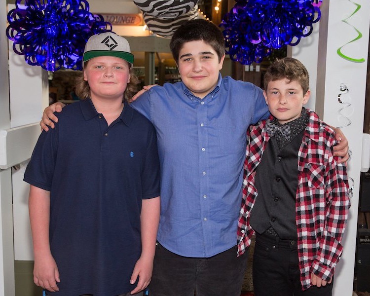 three students smiling at prom