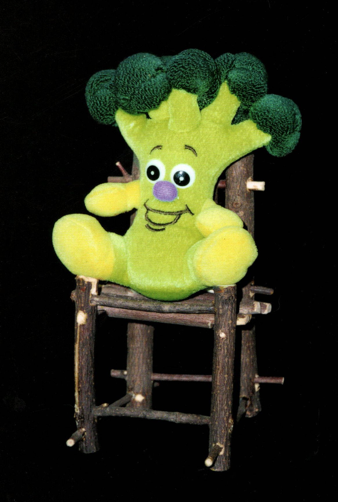 plush toy broccoli with big smile in wooden chair